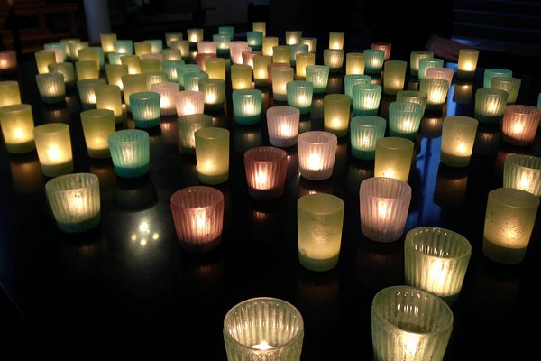 UKM | Eine größere Anzahl von Teelichtern leuchten im Dunkeln.