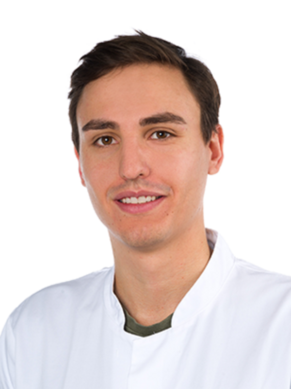 UKM | Zahnarzt der Klinik für Parodontologie. Er trägt einen weißen Kittel und lächelt. Portraitaufnahme