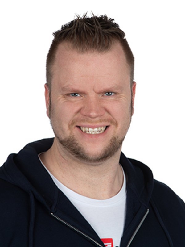 UKM Klinik für Psychosomatische Medizin und Psychotherapie | Hendrik Meyer | Er trägt ein weißes T-Shirt und eine schwarze Jacke und lacht in die Kamera.