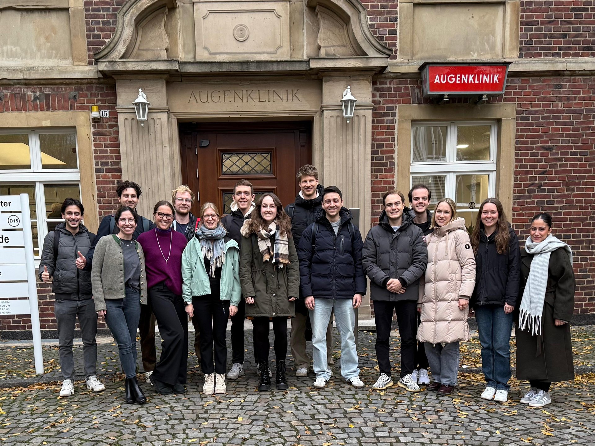 UKM Augenklinik | Gruppe junger Student*innen vor dem Gebäude der Augenklinik.