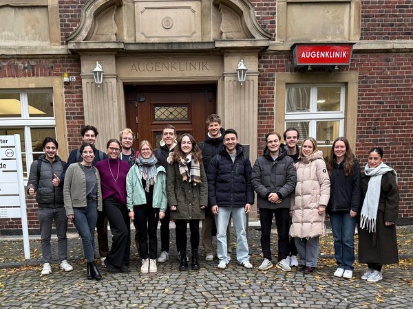 UKM Augenklinik | Gruppe junger Student*innen vor dem Gebäude der Augenklinik.