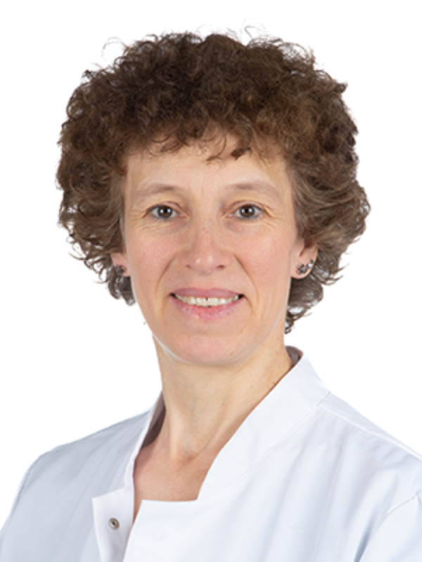 UKM | Portraitfoto einer Mitarbeiterin der Angiologie. Sie trägt einen weißen Kittel und lächelt.