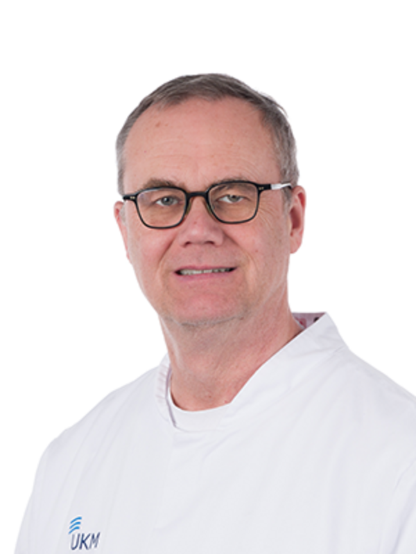 UKM | Portraitaufnahme eines Arztes der Poliklinik für Parodontologie | Er trägt eine Brille und lächelt.