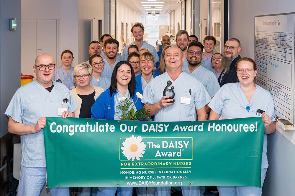 UKM Daisy Award | Gruppenbild der Inensivstation. Sie halten einen Daisybanner in den Händen.