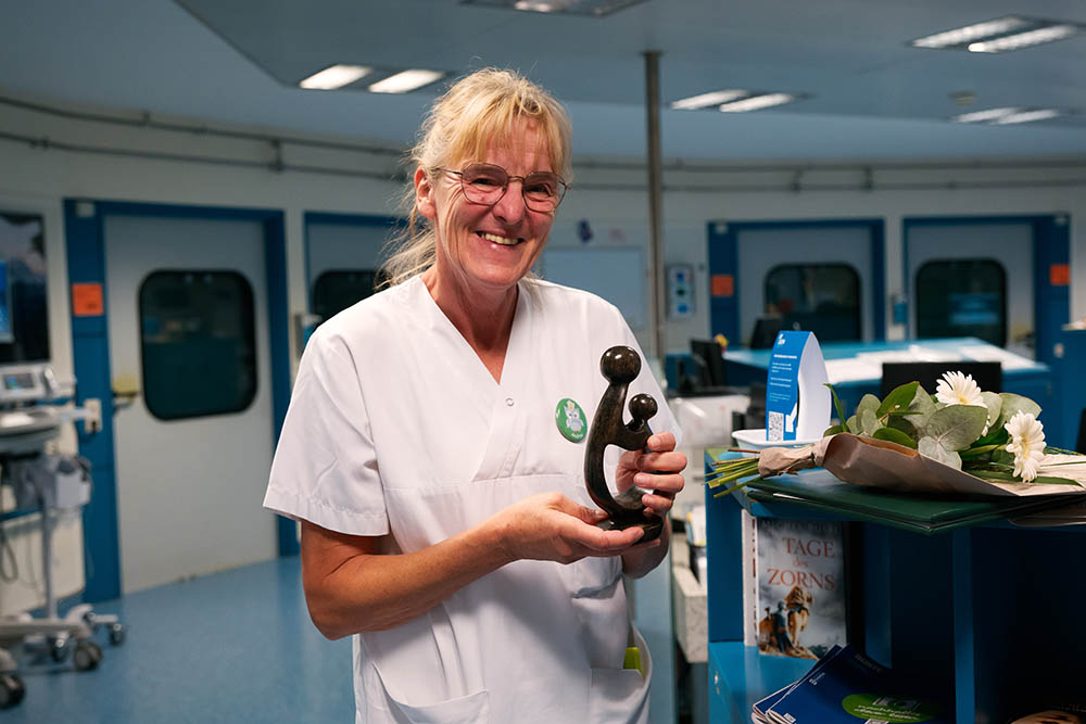 UKM Daisy Award | Andrea Krümpel hält den Daisy Award in den Händen und lächelt in die Kamera.